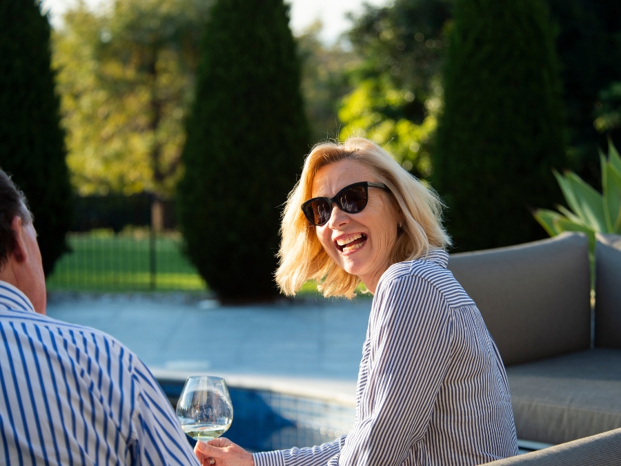 A picture of 2 wealthy southerners having a happy converstation by a tennis court, to illustrate Gerardi Wealth Management's mission of keeping the wealthy wealthy.